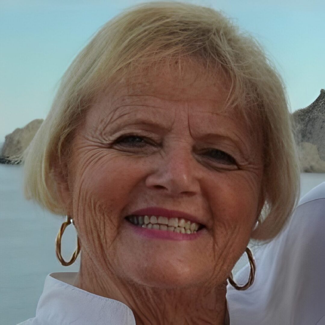 Smiling older woman with beach background.